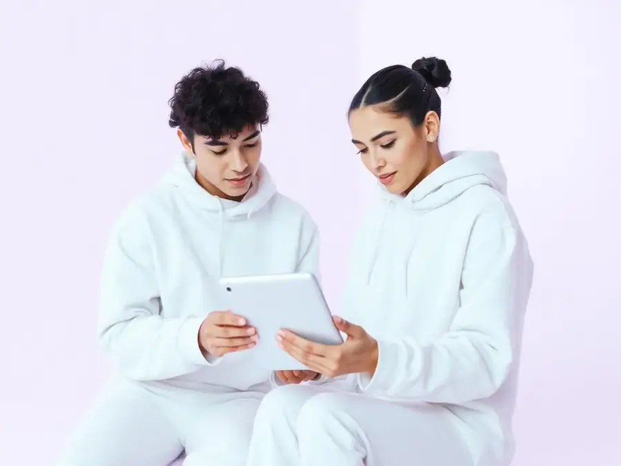 Two artists reviewing their release on a tablet